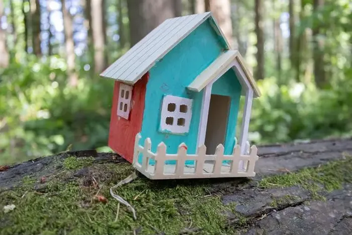 Framed Print : Collection of birdhouses made by children and placed on fallen trees in the forest