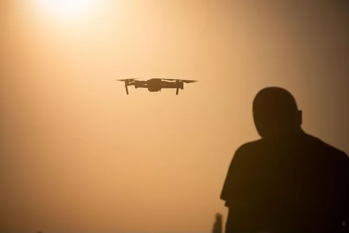 Framed Print : Color image of a man flying a drone at sunrise Framed Print : Color image of a man flying a drone at sunrise