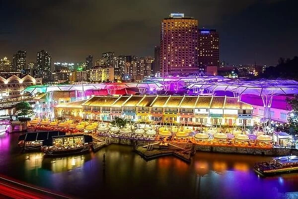 Colorful light building at night in Clarke Quay market with river at Singapore. Asian tourism, modern city life, or business finance and economy conce