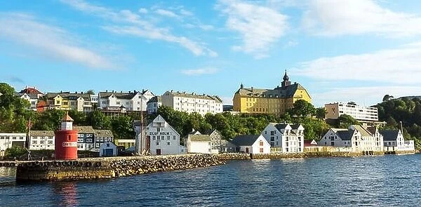 Colorful scene in Alesund port town on western coast of Norway. Pier and lighthouse against the bright day sky