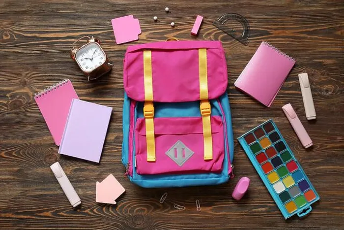 Framed Print : Colorful school backpack with notebooks, watercolors and alarm clock on brown wooden background Framed Print : Colorful school backpack with notebooks, watercolors and alarm clock on brown wooden background