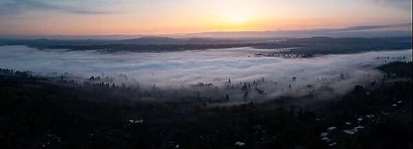 A colorful sunrise illuminates a layer of fog that covers the scenic Willamette River not far south of Portland, Oregon