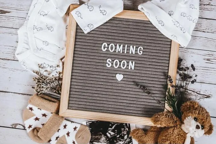 Framed Print : Coming soon sign. Baby announcement sign on a rustic white background. Coming soon concept Framed Print : Coming soon sign. Baby announcement sign on a rustic white background. Coming soon concept