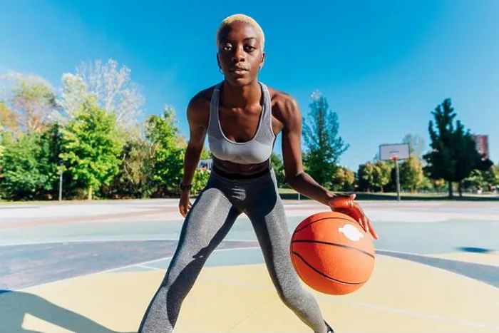 Framed Print : Confident sportswoman playing basketball in sports court Framed Print : Confident sportswoman playing basketball in sports court