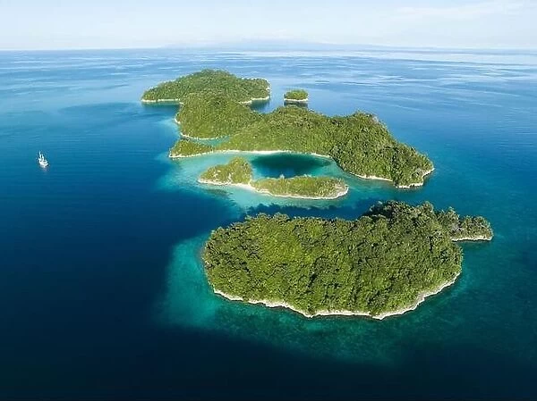 Coral reefs surround the rugged limestone islands that rise from West Papua's seascape. This remote part of Indonesia has high marine biodiversity