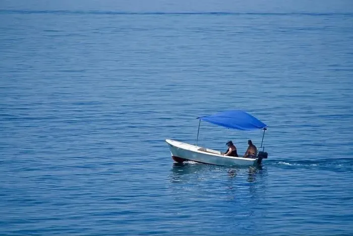 Framed Print : Couple in a little boat with a blue top on the sea