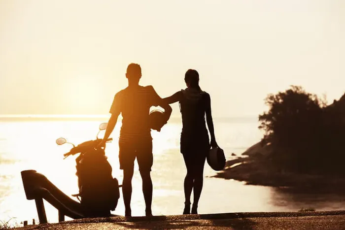 Framed Print : Couple's silhouettes stands with motorcycle against sunset sea bay