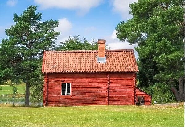 Cozy red timber cottage with bright and sunny summer day in Åland, Finland