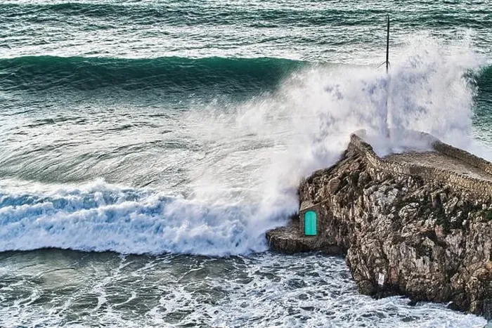 Framed Print : Crashing waves agains the rocks with a small green door Framed Print : Crashing waves agains the rocks with a small green door