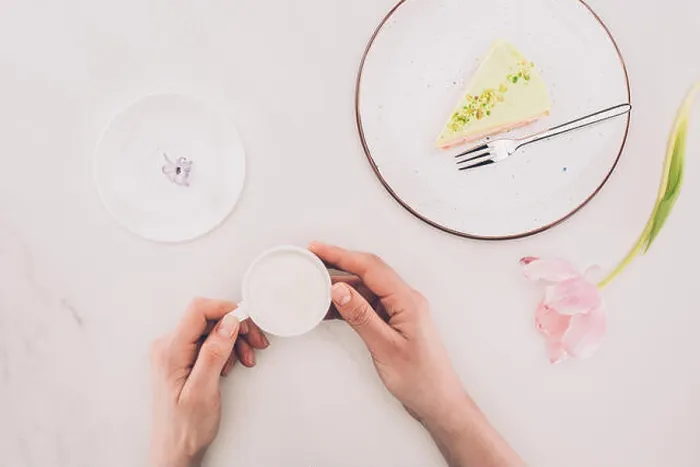 Framed Print : cropped shot of woman with cup of milk and piece of cake on plate on white surface Framed Print : cropped shot of woman with cup of milk and piece of cake on plate on white surface