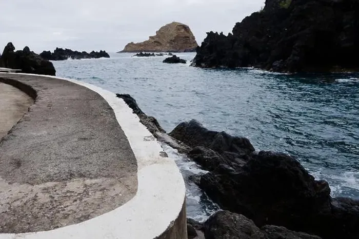 Framed Print : Curved concrete walkway leads to the rocky coastline and serene waters at Porto Moniz natural pools Framed Print : Curved concrete walkway leads to the rocky coastline and serene waters at Porto Moniz natural pools