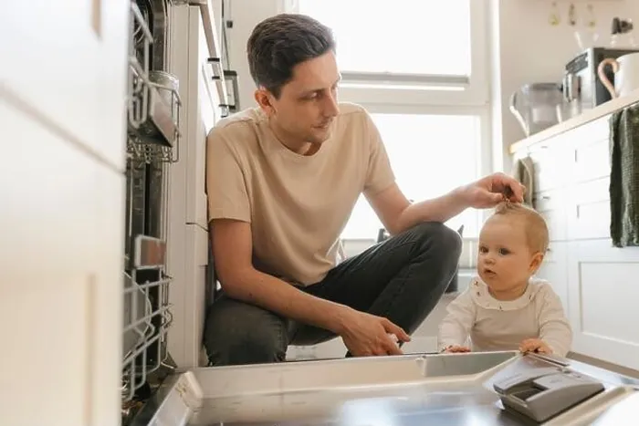 Framed Print : Cute baby girl and father loading utensils in dishwasher in kitchen at home Framed Print : Cute baby girl and father loading utensils in dishwasher in kitchen at home