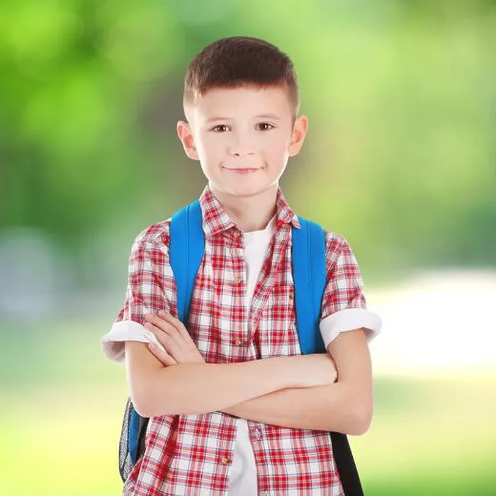 Framed Print : Cute boy with backpack on blurred green background. School concept Framed Print : Cute boy with backpack on blurred green background. School concept