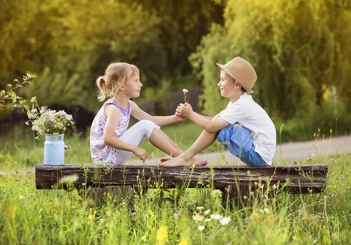 Framed Print : Cute boy and girl in love. They sitting on bench at sunset Framed Print : Cute boy and girl in love. They sitting on bench at sunset