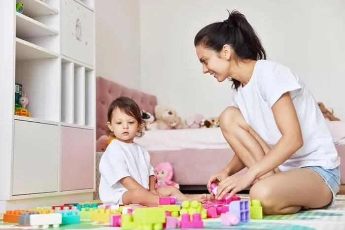 Framed Print : cute caucasian baby girl and her mother playing with toy bricks in the children room, having fun together Framed Print : cute caucasian baby girl and her mother playing with toy bricks in the children room, having fun together