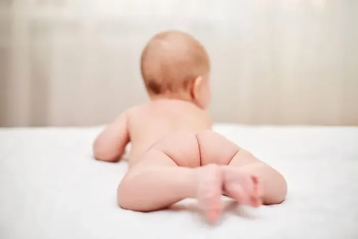 Framed Print : Cute little baby in diaper on bed