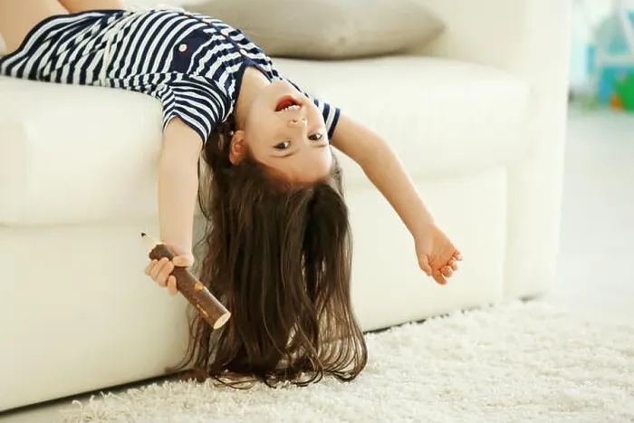 Framed Print : Cute little girl sings in an imagine microphone lying on sofa in the modern room Framed Print : Cute little girl sings in an imagine microphone lying on sofa in the modern room