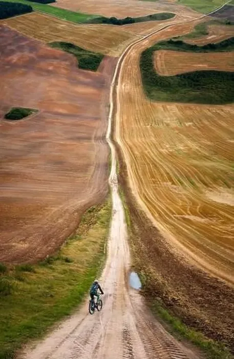 Framed Print : Cyclist on road amongst colorlful meadows in warp perspective, Mazury Poland Framed Print : Cyclist on road amongst colorlful meadows in warp perspective, Mazury Poland