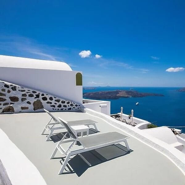 Deck chairs on the terrace with sea view. Luxury travel background, summer scenery in Santorini, white architecture resort, couple honeymoon, wedding