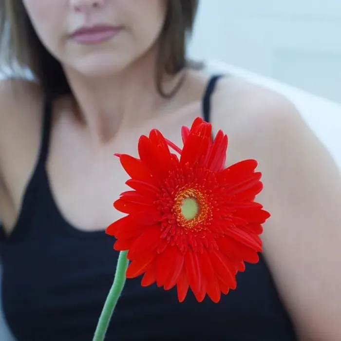 Framed Print : Defocused attractive woman holding a gerbera Framed Print : Defocused attractive woman holding a gerbera