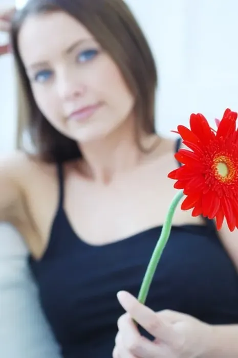 Framed Print : Defocused attractive woman holding a red flower