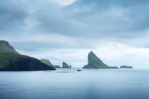 Dramatic view on Drangarnir and Tindholmur sea stacks in Atlantic ocean, Faroe Islands. Landscape photography