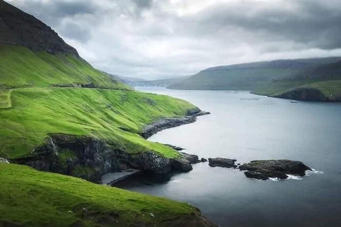 Framed Print : Dramatic view of green hills of Vagar island and Sorvagur town on background. Faroe islands, Denmark. Landscape photography