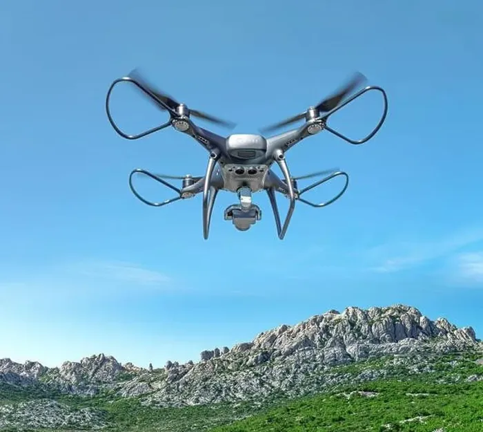 Framed Print : A drone with a camera flies against the backdrop of a mountain landscape Framed Print : A drone with a camera flies against the backdrop of a mountain landscape