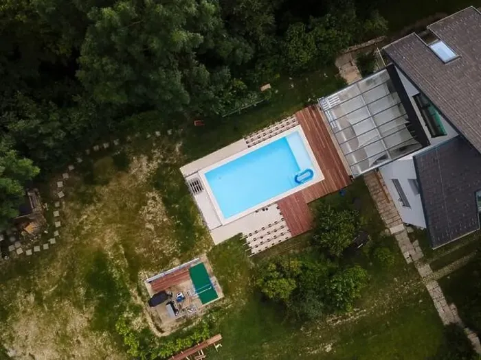 Framed Print : Drone flight over beautiful green garden with pool and the wooden terrace of the pool is currently in progress