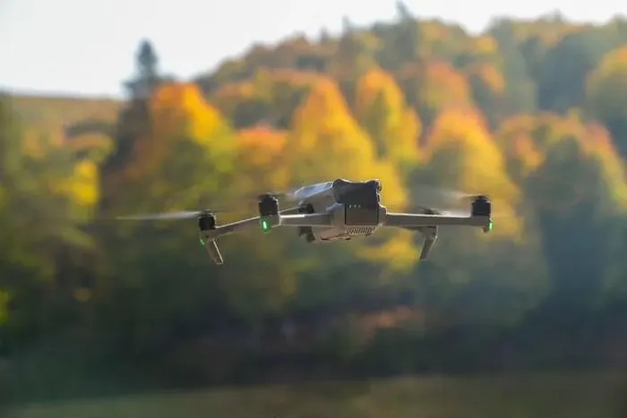 Framed Print : A drone is flying over a lake with trees in the background Framed Print : A drone is flying over a lake with trees in the background