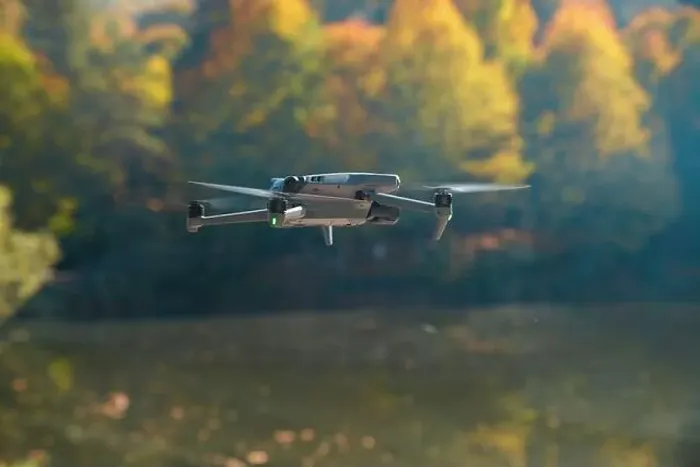 Framed Print : A drone is flying over a lake with trees in the background Framed Print : A drone is flying over a lake with trees in the background