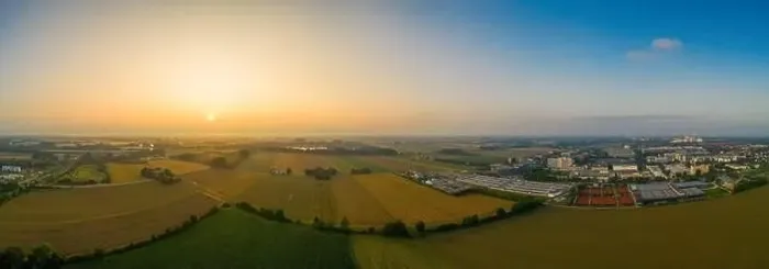 Framed Print : Drone footage - sunrise view over fields and a nearby situated business district Framed Print : Drone footage - sunrise view over fields and a nearby situated business district