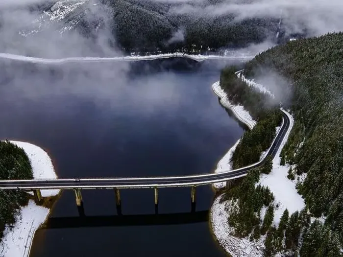 Framed Print : Drone photography from a high altitude of a road and a bridge crossing a mountain lake