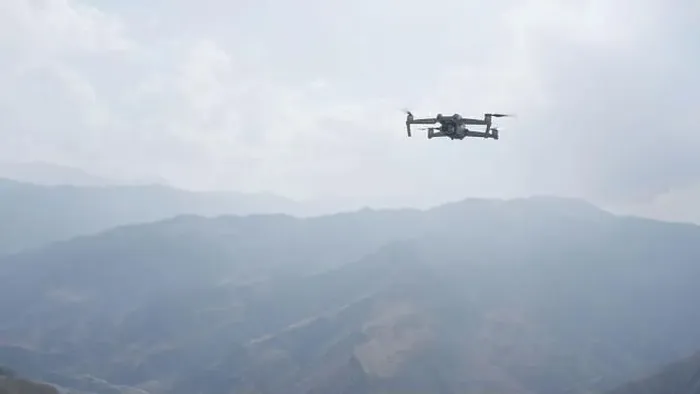 Framed Print : Drone quad copter against mountain in morning haze. Action. Video shooting of forested hills Framed Print : Drone quad copter against mountain in morning haze. Action. Video shooting of forested hills