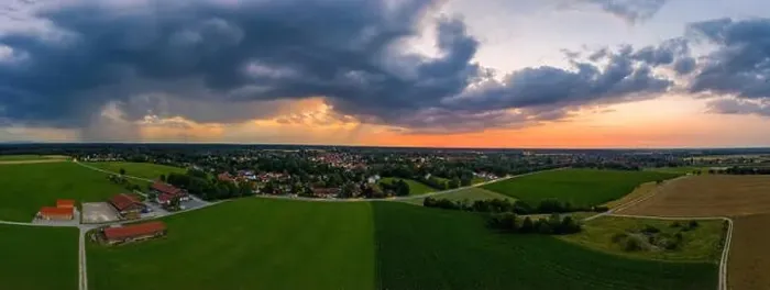Framed Print : A drone shot of a sunset of a town, while rain clouds are coming Framed Print : A drone shot of a sunset of a town, while rain clouds are coming
