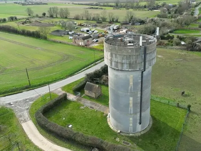 Framed Print : Drone view of a concrete water tower which has an array of 5G antennas on its circular roof Framed Print : Drone view of a concrete water tower which has an array of 5G antennas on its circular roof