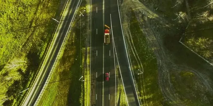 Framed Print : Drone view of moving cars on country side road with beautiful green landscape around Framed Print : Drone view of moving cars on country side road with beautiful green landscape around