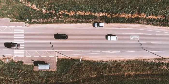 Framed Print : Drone view of moving cars on country side road with crosswalk, bus stop and field around Framed Print : Drone view of moving cars on country side road with crosswalk, bus stop and field around