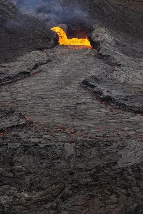 Framed Print : Drone view of stream of hot orange lava flowing through mountainous terrain in morning in Iceland Framed Print : Drone view of stream of hot orange lava flowing through mountainous terrain in morning in Iceland