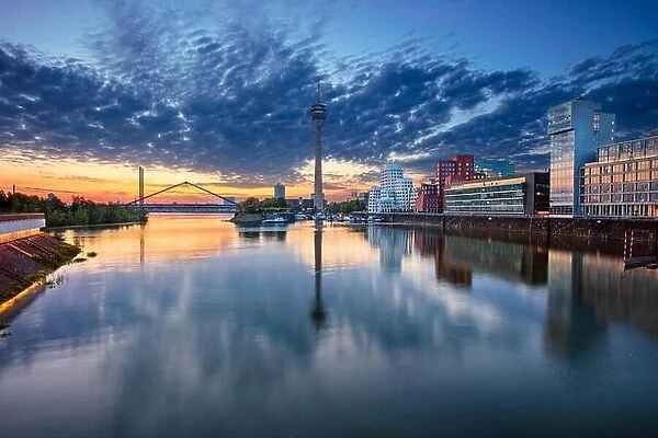 Düsseldorf, Germany. Cityscape image of Düsseldorf, Germany with the Media Harbour and reflection of the city in the Rhine river, during sunrise