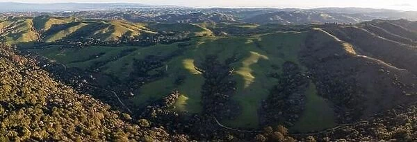 Early morning sunlight shines on the green hills of the east bay, near San Francisco Bay. These hills in California turn green during winter months