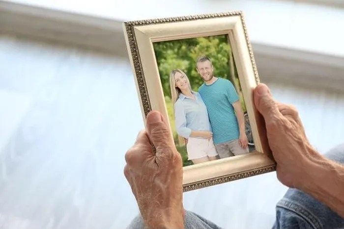 Framed Print : Elderly man holding photo frame with picture of young couple. Happy memories concept Framed Print : Elderly man holding photo frame with picture of young couple. Happy memories concept