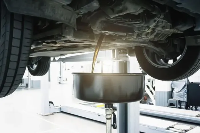 Framed Print : Engine oil change in car service. Auto is on hydraulic lift in garage workshop, process of draining old dark used oil Framed Print : Engine oil change in car service. Auto is on hydraulic lift in garage workshop, process of draining old dark used oil