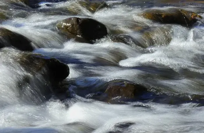 Framed Print : Environment. Fast-flowing crystal clear water flows by rocks in a large stream Framed Print : Environment. Fast-flowing crystal clear water flows by rocks in a large stream