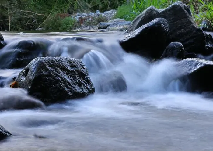 Framed Print : Environment. Fast-flowing crystal clear water flows by rocks in a large stream Framed Print : Environment. Fast-flowing crystal clear water flows by rocks in a large stream