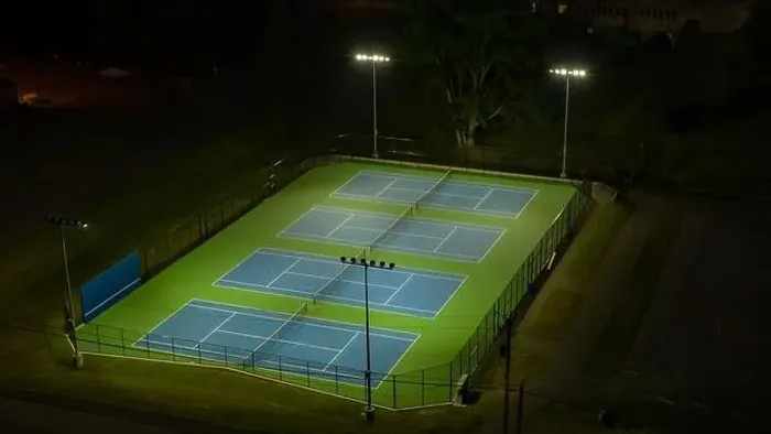 Framed Print : Evening aerial video of outdoor blue tennis courts with pickleball lines with lights turned on Framed Print : Evening aerial video of outdoor blue tennis courts with pickleball lines with lights turned on