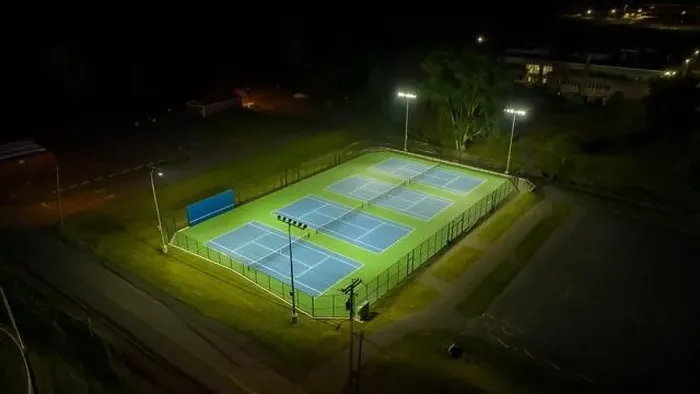 Framed Print : Evening aerial video of outdoor blue tennis courts with pickleball lines with lights turned on Framed Print : Evening aerial video of outdoor blue tennis courts with pickleball lines with lights turned on