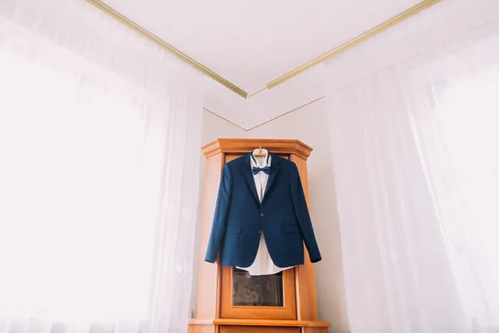 Framed Print : Excellent expensive blue suit hanging in the interior of hotel room Framed Print : Excellent expensive blue suit hanging in the interior of hotel room
