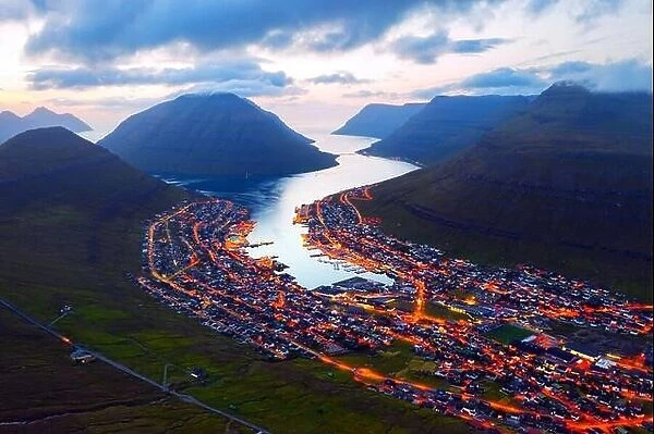Fantastic aerial evening cityscape of Klaksvik town with glowing streets and fjord, Bordoy island, Faroe islands, Denmark. Landscape photography