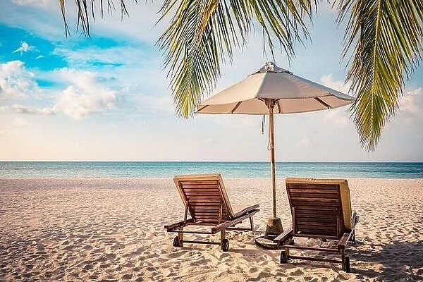 Fantastic beach couple with two sun beds loungers under umbrella and palm leaves. Tropical nature paradise island shore coast sea view, horizon